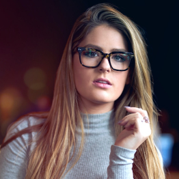 Blonde woman with glasses and grey sweater